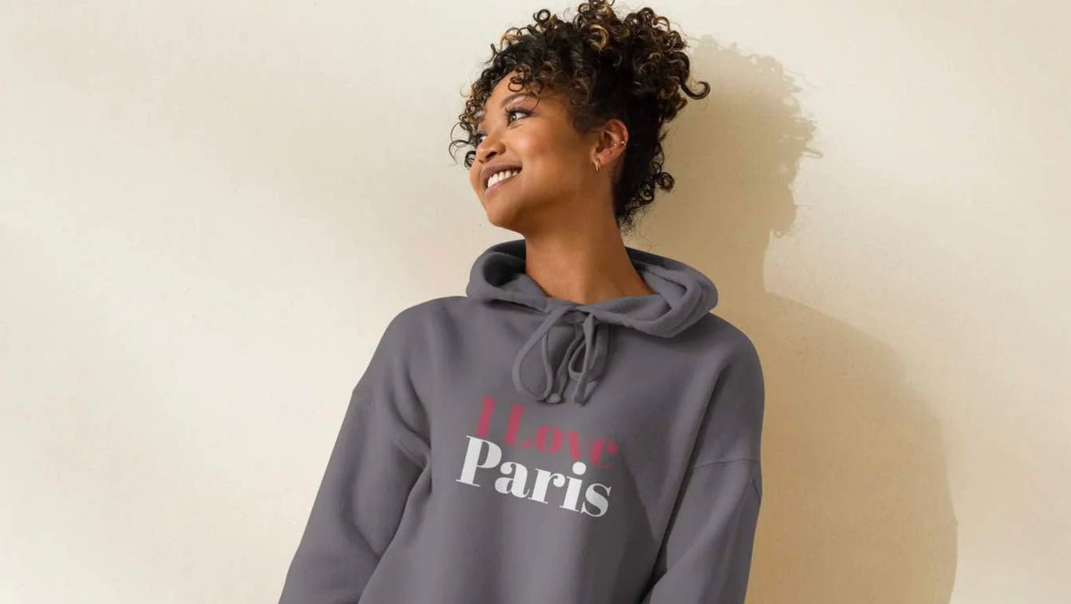 Smiling woman in grey Paris hoodie – bestselling graphic hoodie by ccanvas