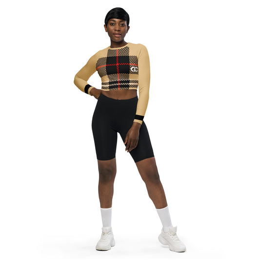 Woman wearing beige long sleeve crop top with red-black plaid center and small logo detail