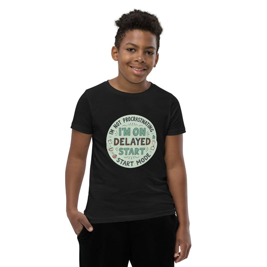 Child wearing black T-shirt with “I’m on delayed start mode” funny quote in round colorful design – max impact print – ccanvas