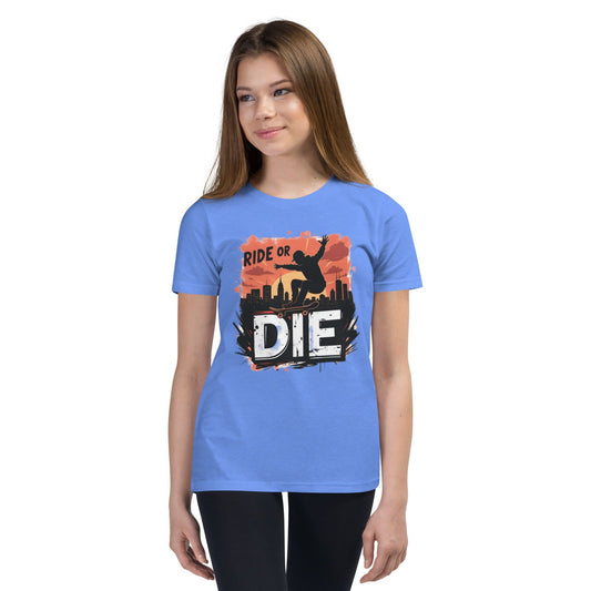 Teen girl wearing blue T-shirt with “Ride or Die” text, skater silhouette, sunset city background and bold urban print – ccanvas