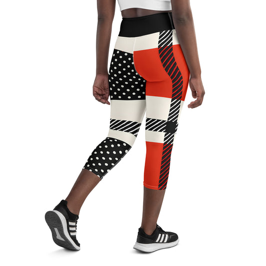 Woman wearing red black and white polka dot capri leggings with bold stripe design, mid-calf length, front view Vs1
