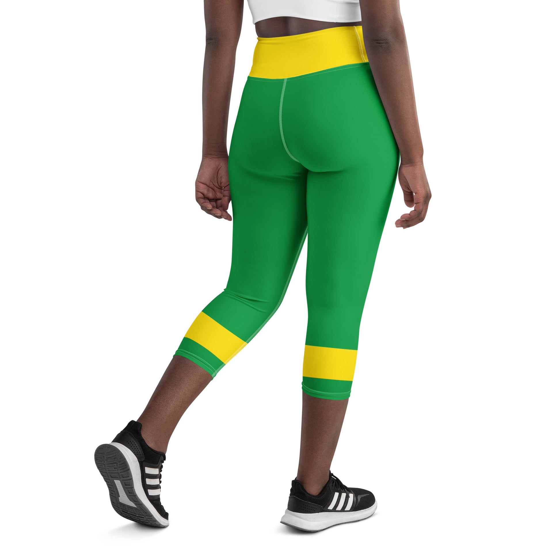 Back view of model in green and yellow Brazil heritage leggings showing the high-waisted fit and leg stripes.

