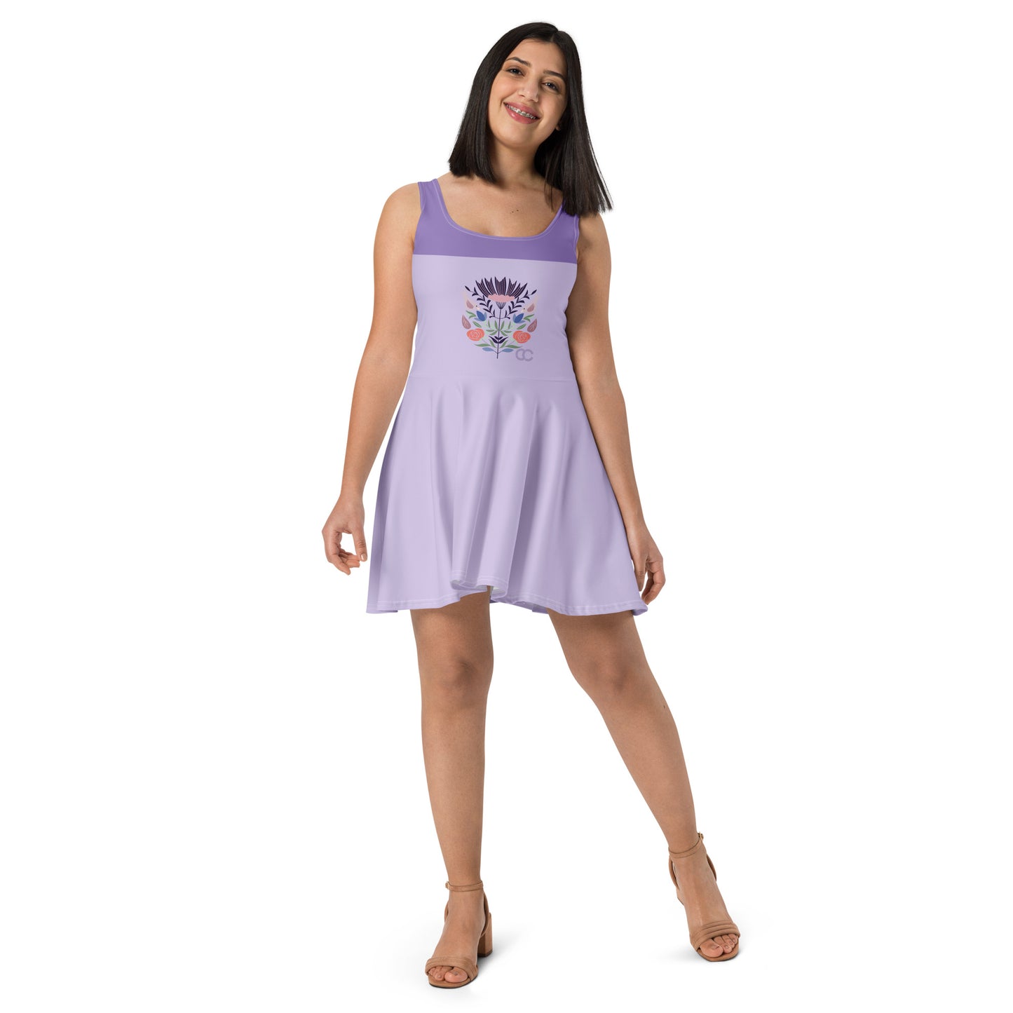 Model wearing a lavender skater dress with a colorful sugar skull graphic and purple waistband by CCANVAS.
