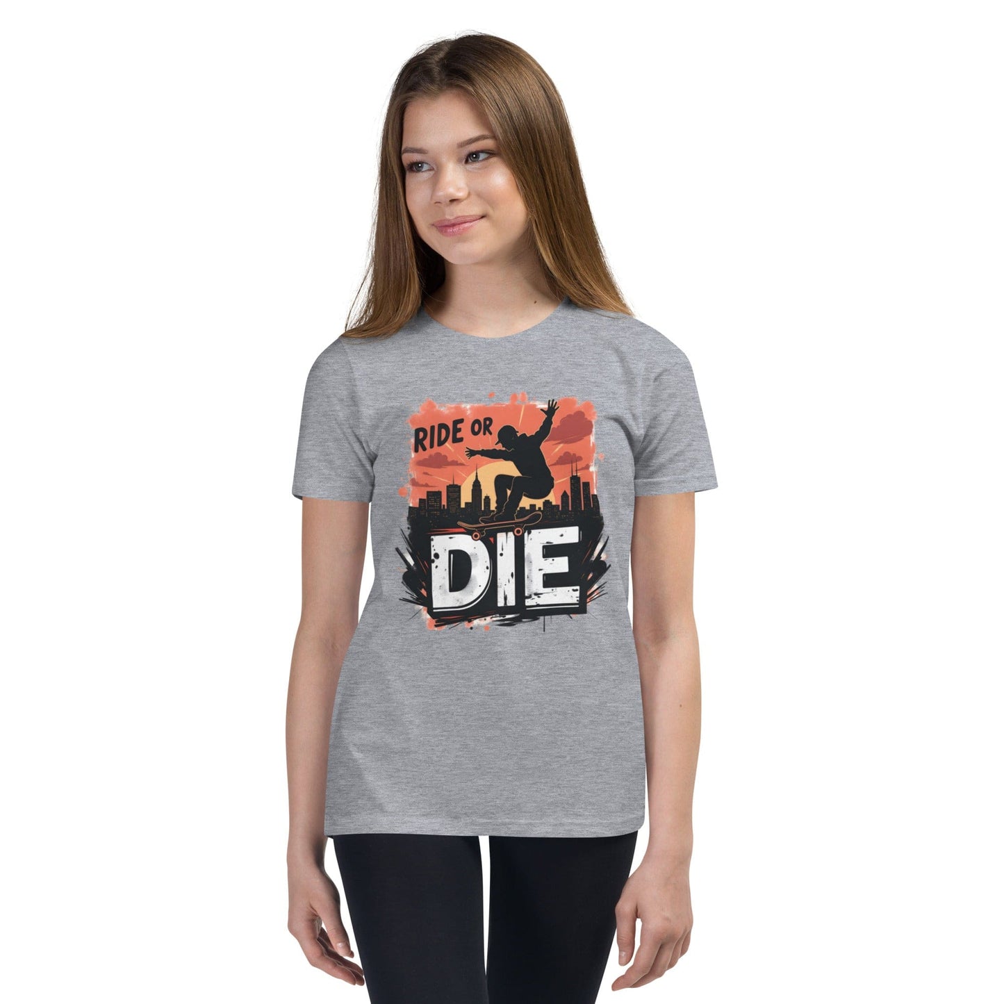 Teen girl wearing white T-shirt with “Ride or Die” text, skater silhouette, sunset city background and bold urban print – ccanvas