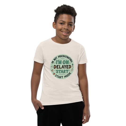 Child wearing Off white T-shirt with “I’m on delayed start mode” funny quote in round colorful design – max impact print – ccanvas