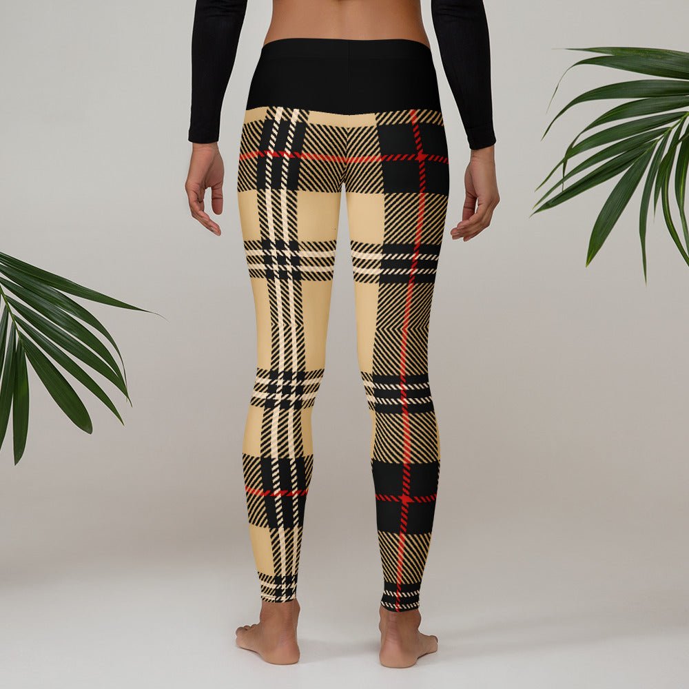 Back view of model in urban plaid leggings showing the black high-waisted band and earthy pattern.
