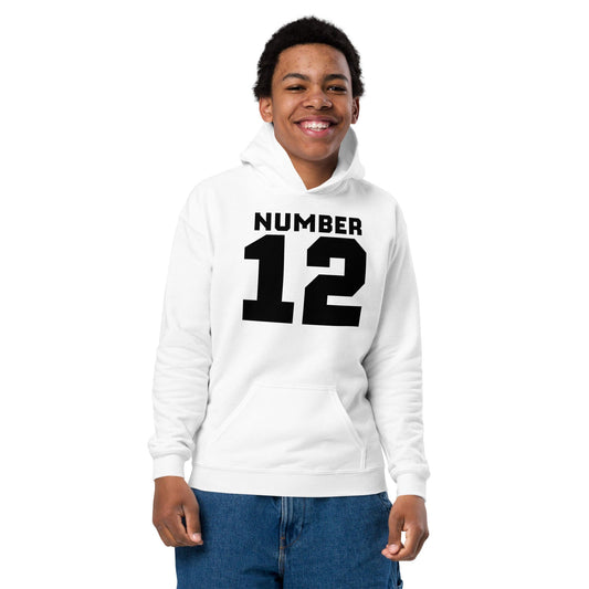 Teen model wearing white hoodie with bold black “NUMBER 12” varsity-style front print - ccanvas
